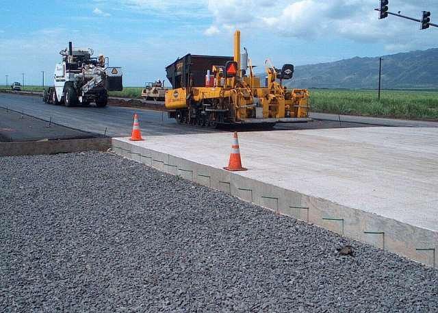 Yellow slipform paver laying concrete pavement