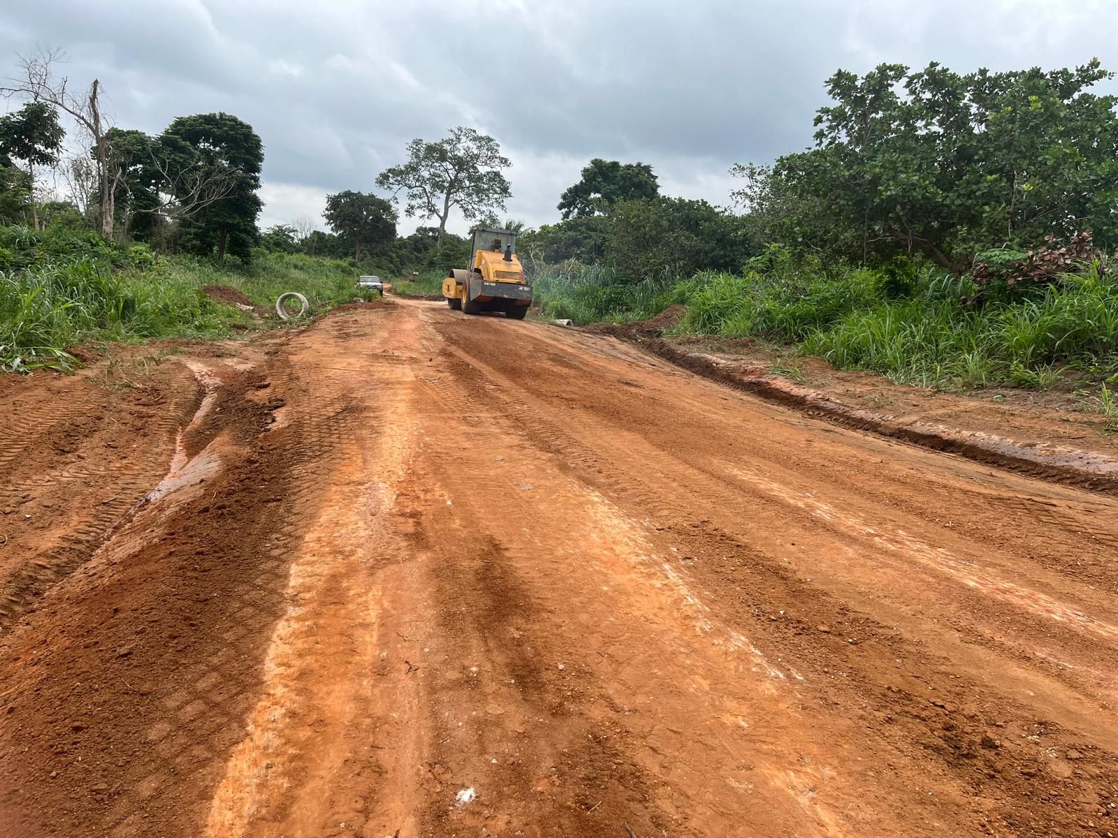 Road roller and culvert pipe on shoulder