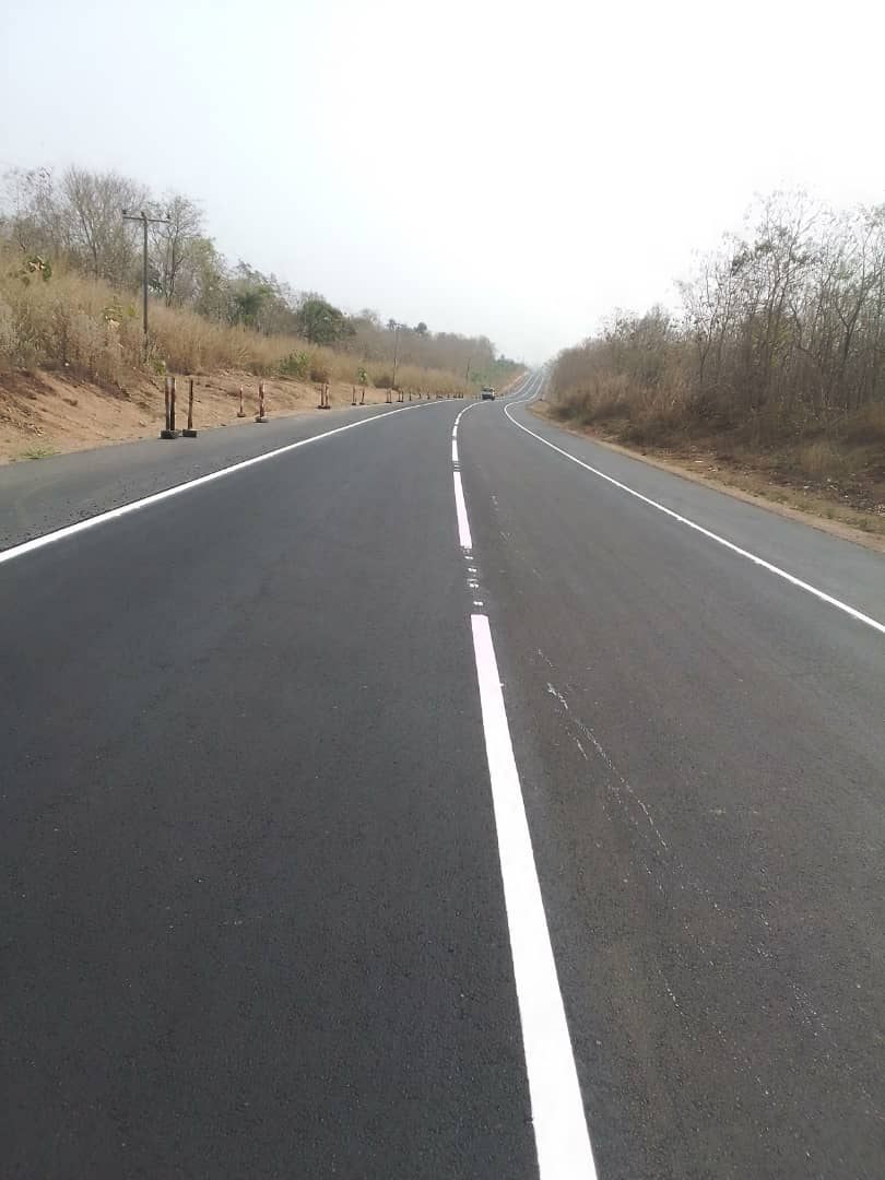 Completed asphalt road with fresh lane markings through rural Ghana