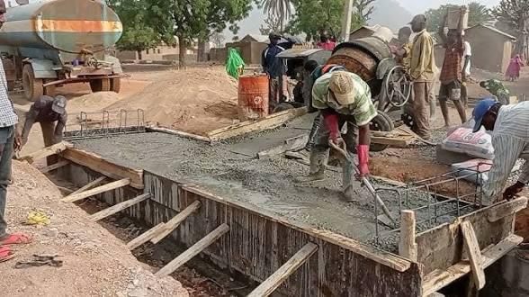 Workers pouring and leveling concrete on site